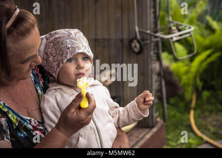 Happy smiling senior grand-mère enfant bébé allaitement campagne porridge Banque D'Images