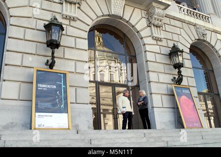 Deux personnes chat devant une fenêtre à San Francisco, à proximité de l'Hôtel de Ville. Banque D'Images