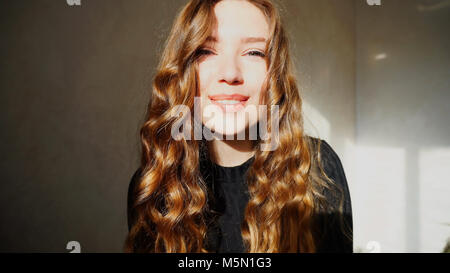 Jeune femme souriante, Looking at Camera avec les cheveux bouclés Banque D'Images