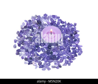 Lavender tea light amethyst bougie entouré par les petites puces tumbled isolé sur fond blanc Banque D'Images