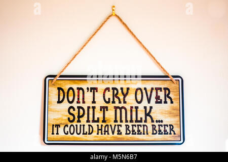 Sign par chaîne sur un mur intérieur, portant le slogan : "plein d'lamenter ne...il aurait pu être la bière". Angleterre, Royaume-Uni. Banque D'Images