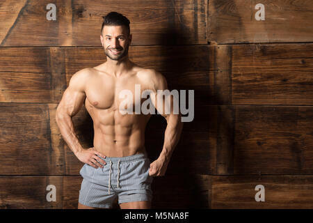 Portrait d'un jeune homme en bonne forme physique montrant son corps bien formé tout en portant des shorts Sports - Athlétisme remise en forme musculaire Bodybuilder Model Posing Banque D'Images