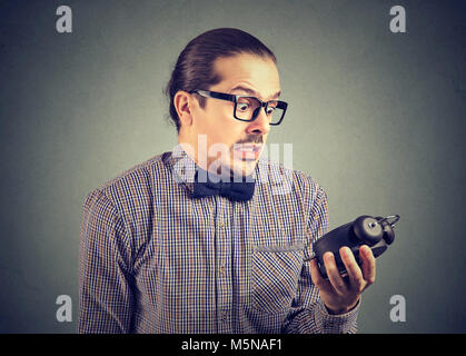 Young man holding formelle réveil et à la fin de l'extrêmement stressé à l'idée. Banque D'Images