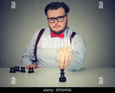 Jeune homme d'affaires graves jouant aux échecs Banque D'Images