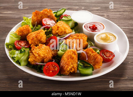 Nuggets de poulet frit et des légumes sur la table en bois Banque D'Images