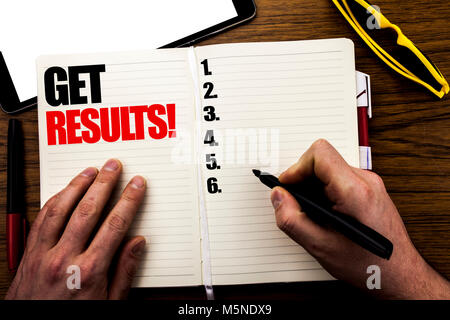 Mot écrit, obtenir des résultats. Concept d'affaires pour atteindre suite livre écrit, avec fond de bois businessman main, doigt écrit sur l'ordinateur portable. Banque D'Images