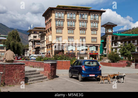 Thimphu, Bhoutan. Le centre de Thimphu : Tour de l'horloge, les chiens errants, Immeuble de bureaux. Banque D'Images