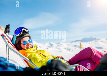 Photo de sports smiling woman lying on chaise longue en hiver resort Banque D'Images