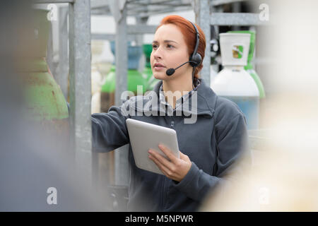 Jolie warehouse manager à l'aide de tablet pc dans un grand entrepôt Banque D'Images