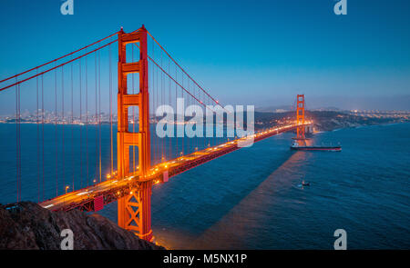 Vue panoramique classique du célèbre Golden Gate avec cargo navire de fret dans le magnifique coucher du soleil au cours de l'après twilight blue hour au crépuscule en été, San Francis Banque D'Images