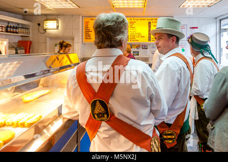 Morris Dancers la Queue de poisson et frites dans un 'Lewes Chippie' entre les spectacles du Festival Folk de Lewes, Lewes, dans le Sussex, UK Banque D'Images