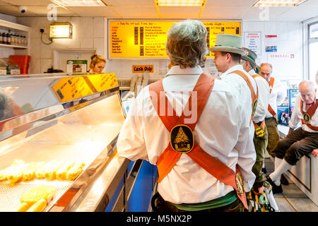 Morris Dancers la Queue de poisson et frites dans un 'Lewes Chippie' entre les spectacles du Festival Folk de Lewes, Lewes, dans le Sussex, UK Banque D'Images