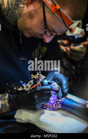 Brighton UK 25 février 2018 - Les tatoueurs au travail à la 11e Convention de Tatouage de Brighton s'est tenue dans le centre de Brighton au cours du week-end d'attirer des artistes tatoueurs du monde entier Crédit : Simon Dack/Alamy Live News Banque D'Images