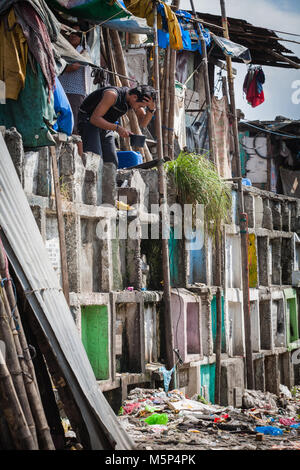 Navotas, Manille, Philippines. 8Th apr 2015. Un homme vu le bain dans le bidonville. Dans le centre de Pasay, District de la région métropolitaine de Manille est un cimetière où plus de 10 000 personnes décédées repose en paix mais il y a aussi plus de deux cent un de la vie, d'un séjour au même endroit côte à côte avec les morts. De nombreuses familles déplacées au cimetière en raison du manque de fonds et qu'ils trouvent le cimetière le meilleur endroit pour mettre un toit sur la tête pour libre. Credit : 20150408-IMG 1581.jpg Images/SOPA/ZUMA/Alamy Fil Live News Banque D'Images