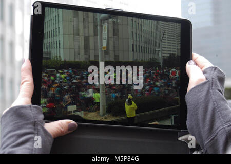 Le Japon. Feb 25, 2018. Les coureurs de marathon peut être vu sur un écran de l'iPad comme ils passent en-avant du bâtiment pendant l'Goberment Tokyo début du Marathon de Tokyo en 2018 à Tokyo, au Japon. Dimanche 25 Février, 2018. Photo par : Ramiro Agustn Vargas Tabares Crédit : Ramiro Agustin Vargas Tabares/ZUMA/Alamy Fil Live News Banque D'Images