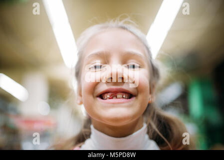 Smiling little girl sans dent, le bonheur des enfants en animalerie. Le caméléon et le client pour enfants Banque D'Images