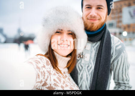 Jeune couple, l'amour sur selfies patinoire. Hiver patinage sur open air, loisirs actifs, homme et femme, à l'ensemble des patins Banque D'Images