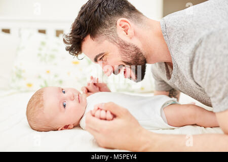 Jeune homme en tant que fier et heureux père joue avec son bébé Banque D'Images