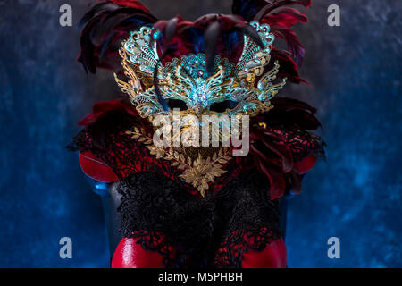 Rouge de Venise, masque et corset rouge avec des morceaux de tissus d'or et de dentelle noire sur metal pectoral. handmade piea pour les fêtes ou réunions de costumes Banque D'Images