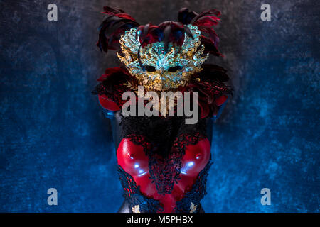 Rouge de Venise, masque et corset rouge avec des morceaux de tissus d'or et de dentelle noire sur metal pectoral. handmade piea pour les fêtes ou réunions de costumes Banque D'Images