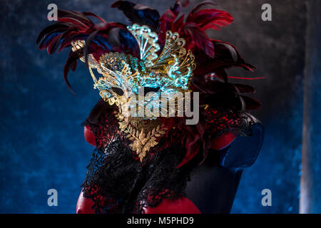 Rouge de Venise, masque et corset rouge avec des morceaux de tissus d'or et de dentelle noire sur metal pectoral. handmade piea pour les fêtes ou réunions de costumes Banque D'Images