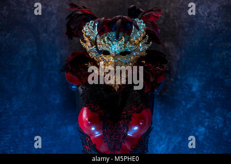 Rouge de Venise, masque et corset rouge avec des morceaux de tissus d'or et de dentelle noire sur metal pectoral. handmade piea pour les fêtes ou réunions de costumes Banque D'Images