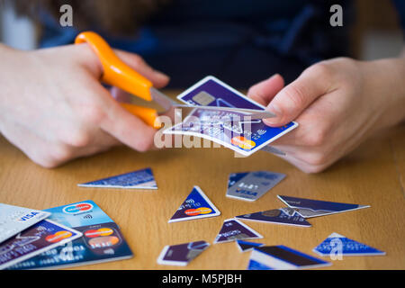 Une femme de couper les cartes de crédit - le concept de la dette de carte de crédit Banque D'Images