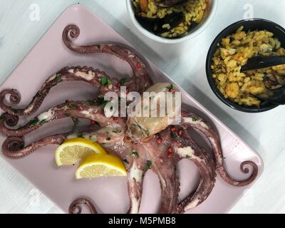 Le poisson frit,riz avec moules et poulpes sur lave avec du citron et de la salade. Banque D'Images