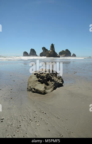 Marée basse révèle un groupe de petites îles à une plage de la côte ouest, île du Sud, Nouvelle-Zélande Banque D'Images