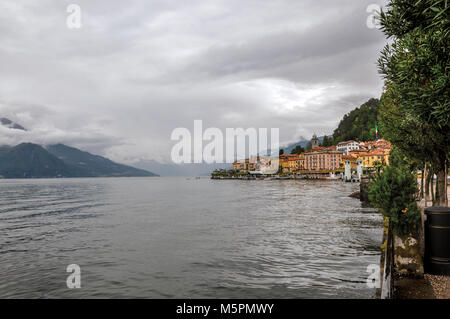 Vue sur le lac de Côme en journée nuageuse avec les bâtiments de Bellagio, un charmant village touristique entre le lac et les montagnes des Alpes. Banque D'Images