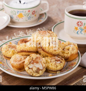 Fromage à la crème à la cannelle gâteau café sur une plaque avec une tasse de café et sucre bol en arrière-plan Banque D'Images