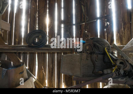 Un vieux bâtiment de stockage, rachitique, avec des séparations dans le mur qui permettent au soleil de briller à travers. Banque D'Images