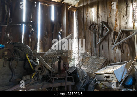 Un vieux bâtiment de stockage, rachitique, avec des séparations dans le mur qui permettent au soleil de briller à travers. Banque D'Images