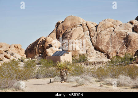 Indian Cove Campground amphitheater et panneaux solaires, Twentynine Palms, CA . Indian Cove Campground se trouve au milieu de l'immense rocher abrupt, formations dont le parc national Joshua Tree est connue. En raison de sa proximité de nombreuses voies d'escalade de roche, c'est un emplacement de camping pour les grimpeurs. Indian Cove est l'un des deux seuls terrains de camping dans le parc qui peuvent être réservés pendant la saison d'hiver ; il est ouvert sur une base du premier arrivé, premier servi du 1er juin au 29 septembre. Les voyageurs qui aiment chaud, hivers secs affluent à Joshua Tree, d'octobre à mai, quand les températures planer entre 70- Banque D'Images