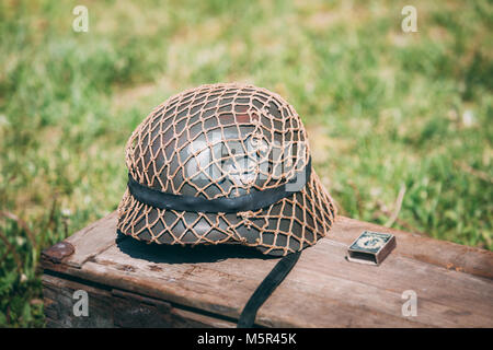 Fermer le casque de métal de soldat d'infanterie de la Wehrmacht, les Forces armées de l'Allemagne nazie durant la Seconde Guerre mondiale, située sur l'ancienne boîte en bois sur le Vert Gr Banque D'Images