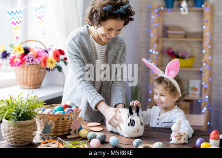 Portrait of happy young family célébrer Pâques à la maison, de la mère et de l'adorable petit garçon jouant avec bunny pet Banque D'Images