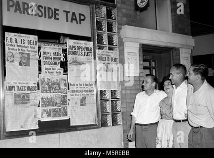 Un groupe se réunit pour lire les manchettes à l'extérieur d'une taverne de Chicago à la fin de la Seconde Guerre mondiale, ca. 1945. Banque D'Images