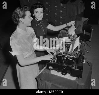 Deux modèles montrent machines à écrire électriques Remington lors d'une convention d'équipement de bureau à Chicago, ca. 1955. La machine à écrire en retour est le modèle moderne de 1955 et la toute première Remington electric est à l'avant à partir de 1925. Banque D'Images