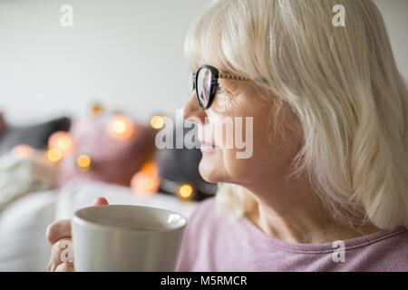 Portrait de profil senior lady holding tasse de thé à la voiture Banque D'Images