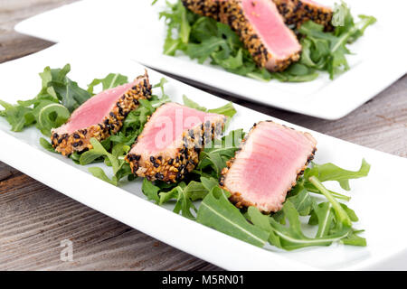 Tataki de thon en croûte de sésame sur fond bois plaque apéritif Banque D'Images