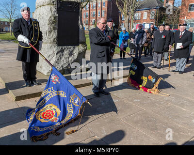 Warrington, Cheshire, Royaume-Uni. 25 févr., 2018. Comme le dernier Post est joué les Porteurs abaisser leurs normes sous le contrôle du Lieutenant-colonel L. Taylor Duff (Ret.), Colonel honoraire du duc de Lancastre's Regimental Association, lors de la commémoration de l'accusation de Pieter's Hill à la guerre des Boers. Crédit : John Hopkins/Alamy Live News Banque D'Images