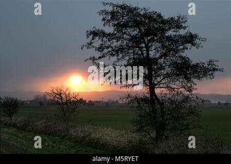 Burscough, Lancashire. Feb 26, 2018. Météo Royaume-uni Météo.UK. Lever du soleil à travers les nuages de neige averses sur Rivington aux premiers signes de 'la bête de l'Est' apparaissent sur Lancashire rural. Amèrement froids et enneigés sont prévus à travers le Royaume-uni cette semaine que la météo souffle depuis la Russie. /AlamyLiveNews MediaWorldImages Crédit : Banque D'Images