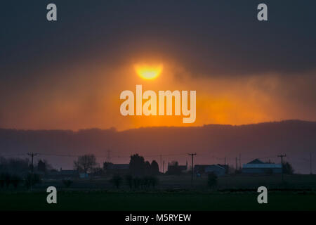 Burscough, Lancashire. Feb 26, 2018. Météo Royaume-uni Météo.UK. Lever du soleil à travers les nuages de neige averses sur Rivington aux premiers signes de 'la bête de l'Est' apparaissent sur Lancashire rural. Amèrement froids et enneigés sont prévus à travers le Royaume-uni cette semaine que la météo souffle depuis la Russie. /AlamyLiveNews MediaWorldImages Crédit : Banque D'Images