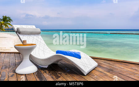 Chaise longue et belle turquoise de l'océan Indien en Maldives Banque D'Images