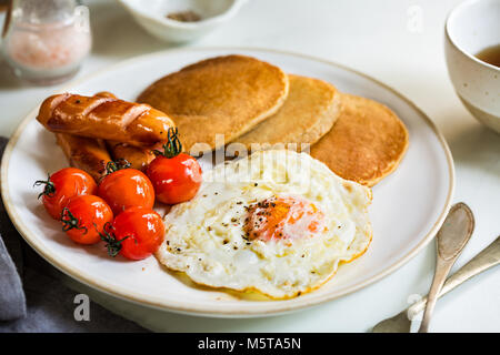 L'avoine banane crêpes avec saucisses, œufs frits et tomates cerises Banque D'Images