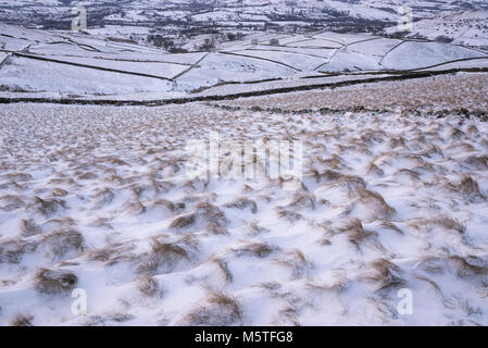 Matin d'hiver enneigé dans les collines du Peak District. Neige emportée sur buttes d'herbe des Landes. Banque D'Images