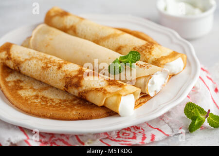 Crêpes minces avec du fromage cottage et les fraises. Un petit-déjeuner traditionnel sain concept. Banque D'Images