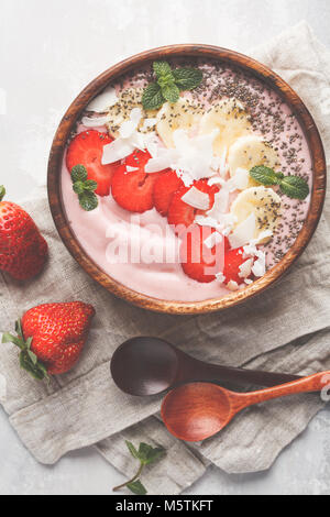 Rose fraise smoothies bol avec Bananiers, cocotiers et chia seeds. La nourriture végétalienne saine concept. Banque D'Images