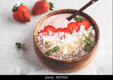 Rose fraise smoothies bol avec Bananiers, cocotiers et chia seeds. La nourriture végétalienne saine concept. Banque D'Images