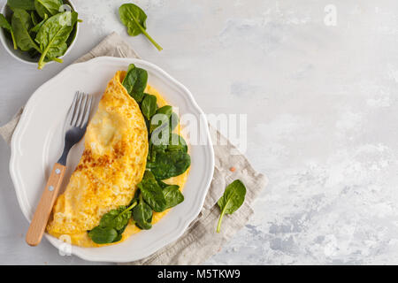 Omelette farcie aux épinards et fromage pour un petit-déjeuner. Banque D'Images